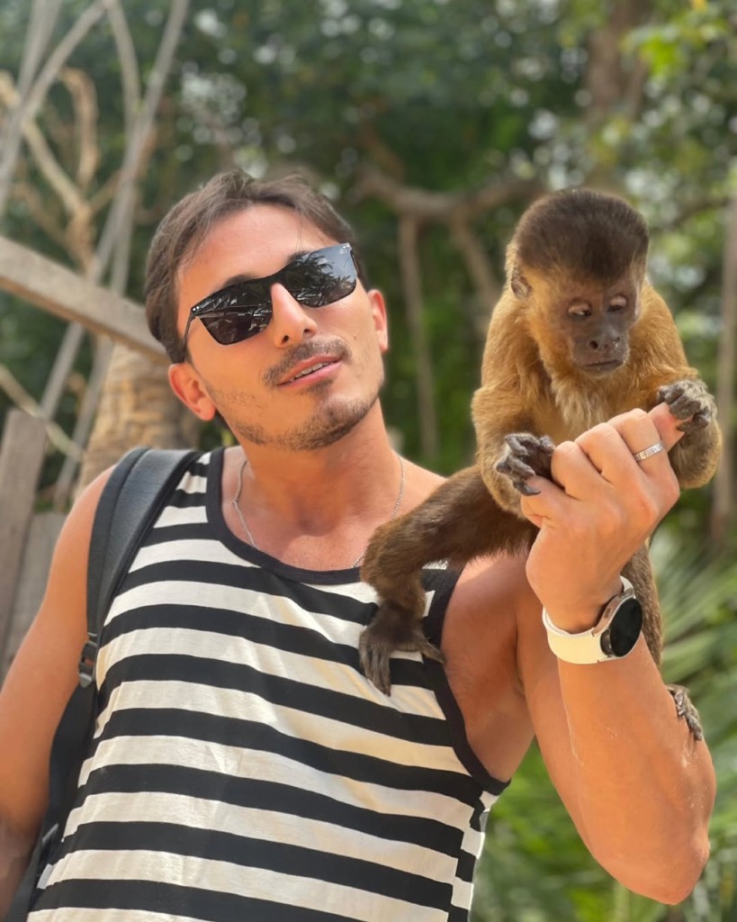 Visitante com macaco-prego no ombro em parada do passeio
