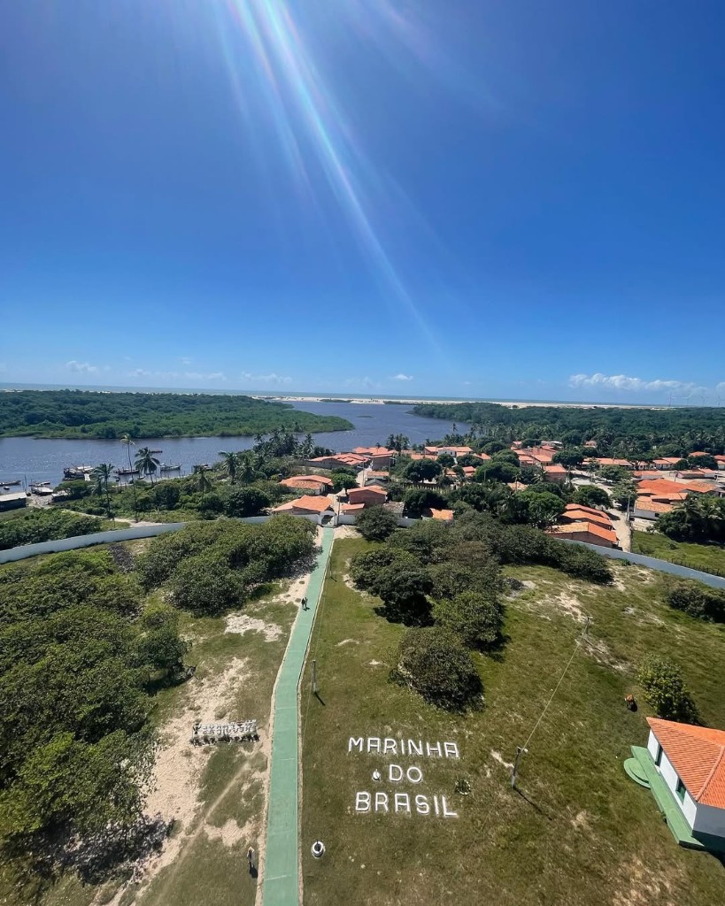 Vista aérea da vila, letreiro Marinha do Brasil, rio e mar ao longe