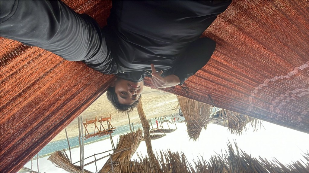 Visitante descansando em rede na beira da praia