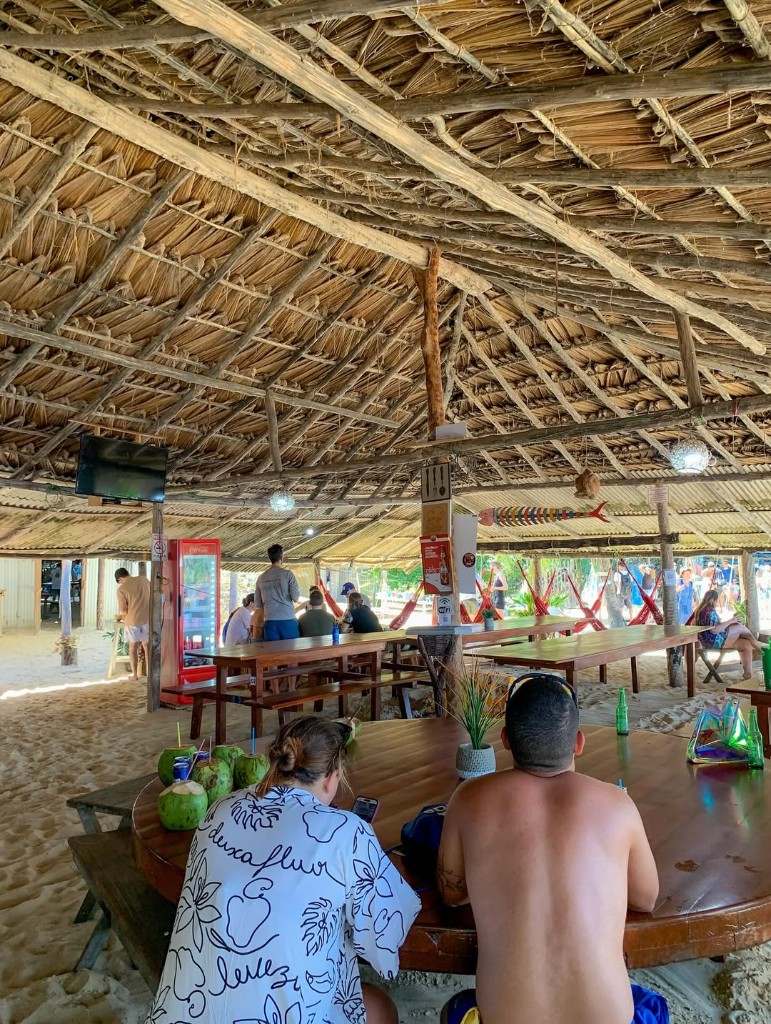 Desembarque da lancha na areia com dunas e vegetação