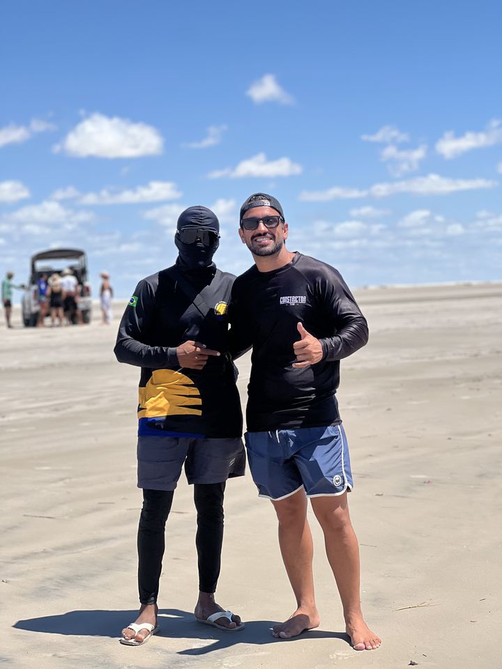 Guia fardado da Amo Lençóis com cliente na praia durante a travessia