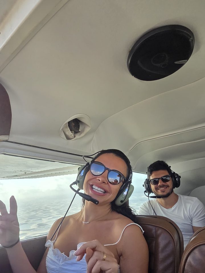 Casal sorrindo durante o sobrevoo pelos Lençóis Maranhenses