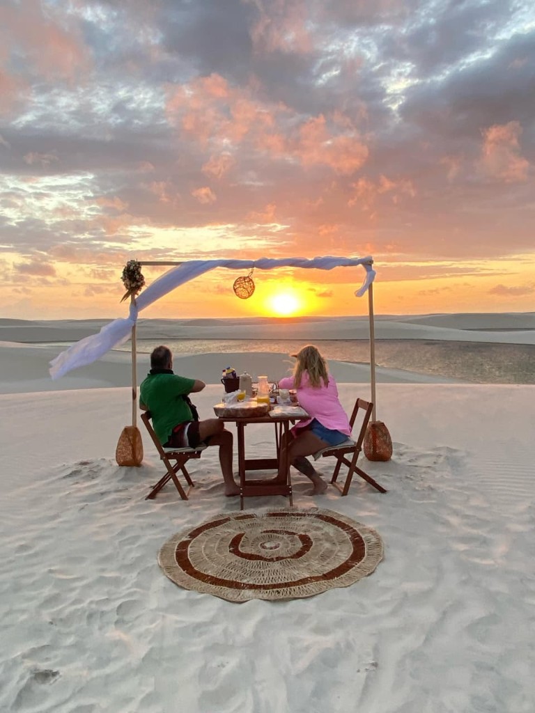 Casal tomando café da manhã ao nascer do sol