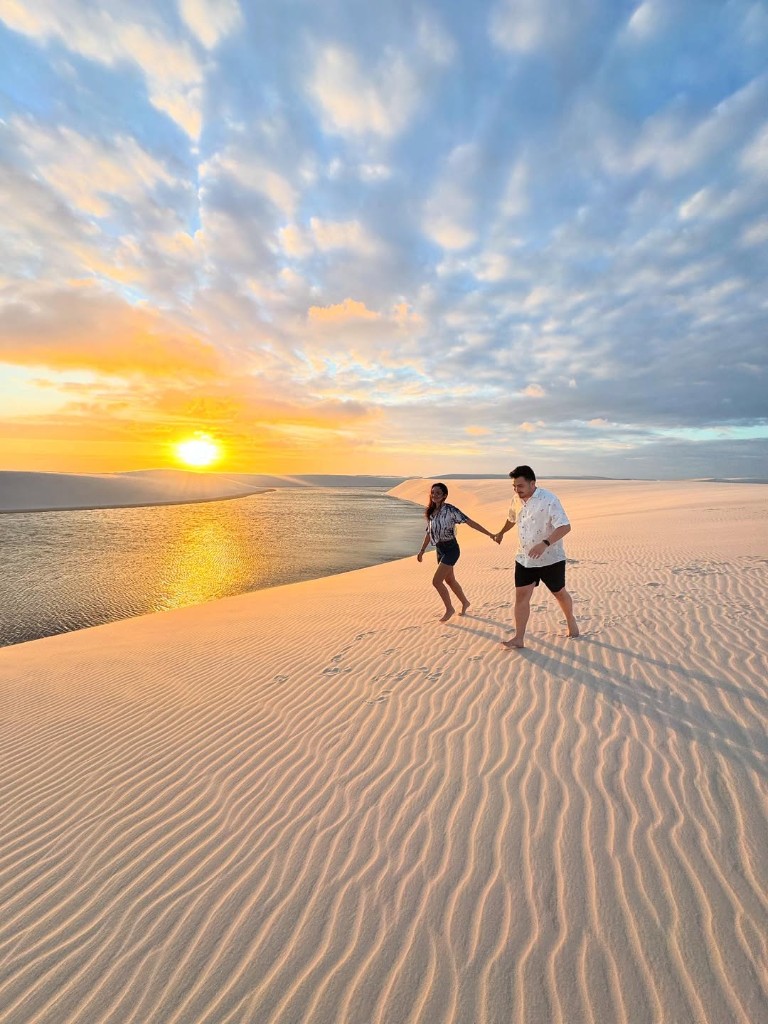 Casal nas dunas ao pôr do sol em Santo Amaro
